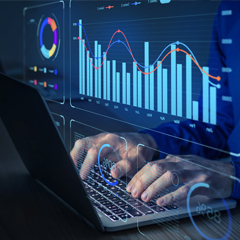 Hands typing on laptop with data