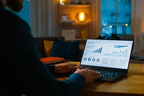 person typing on computer with data charts