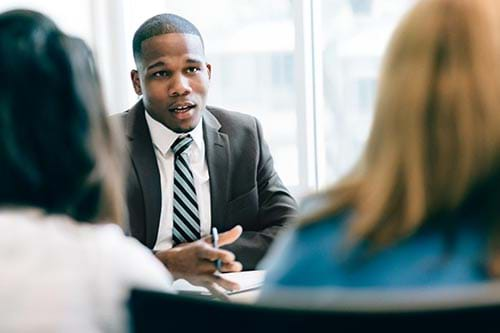 person meeting with two employees