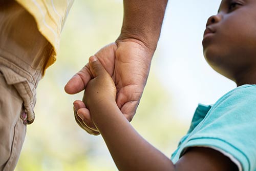 parent holding a childs hand