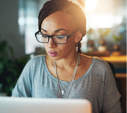 student with glasses studying on computer