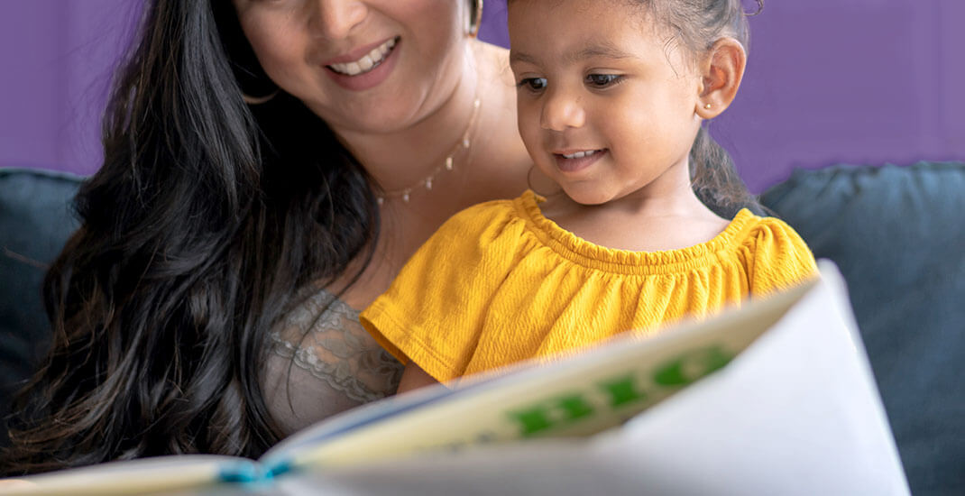 mom and daughter looking at a book