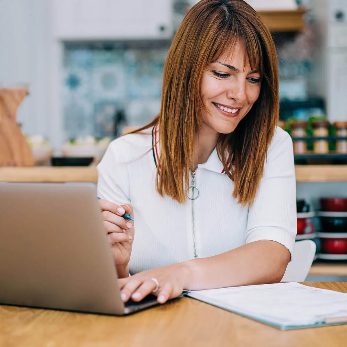 lady on laptop with pen and pad